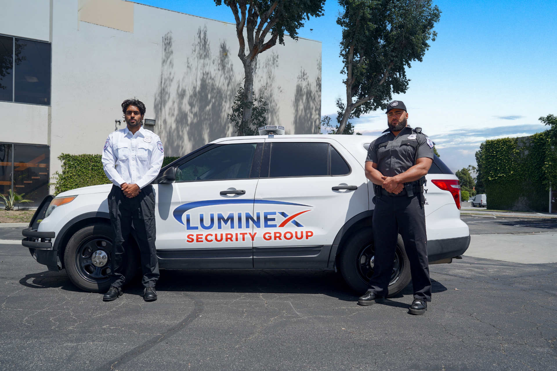 Two Luminex officers posted beside a marked patrol SUV