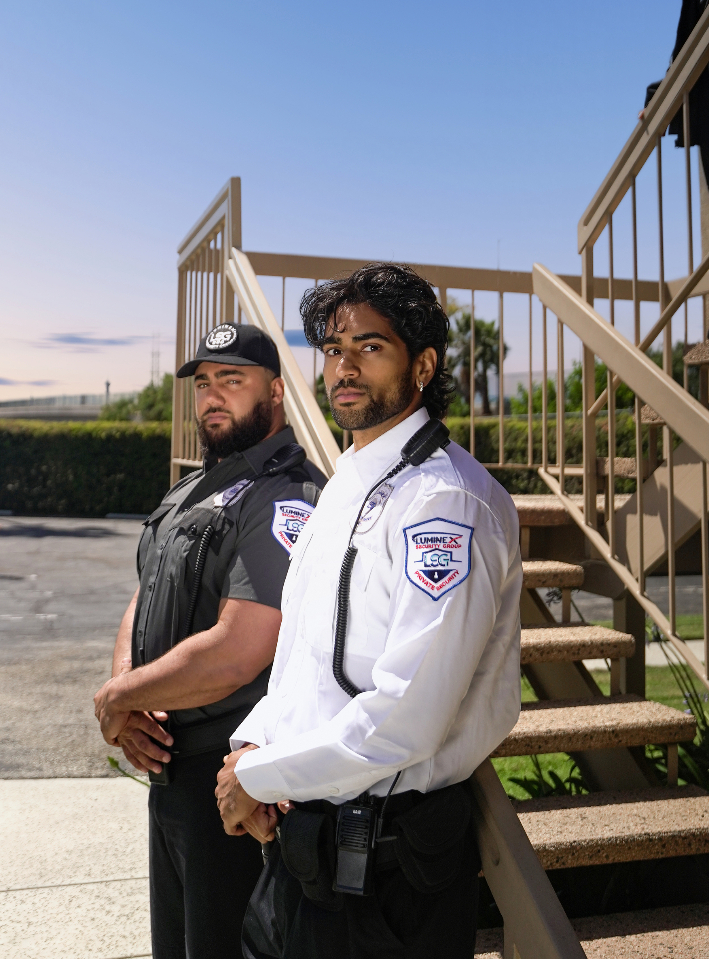 Luminex officers in gray and white uniforms standing post near exterior stair